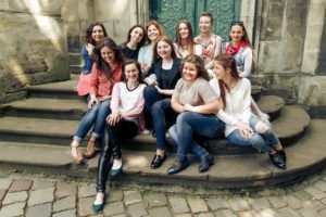 young happy women sitting on stairs posing